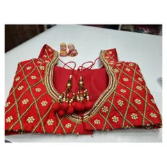 The finished red blouse with its diamond-pattern work and matching red tassels, ready for the client.