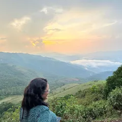 A quiet moment of reflection overlooking the rolling hills of Chikmagalur. The views from the top are a perfect reward after a refreshing trek with the group.