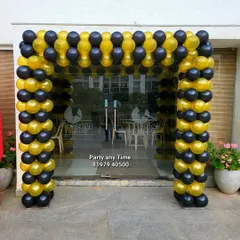 A black and gold balloon arch for a corporate event or store opening.