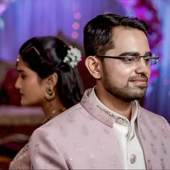 An artistic couple portrait with the groom in the foreground. This composition adds depth and tells a story of two individuals coming together.
