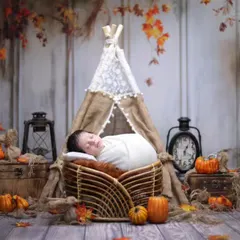 An autumn-inspired rustic photoshoot. The warm colors of the fall leaves, combined with a miniature teepee and vintage props, create a wonderfully cozy atmosphere.