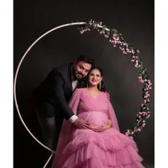Celebrate your journey to motherhood with a beautiful couple's photoshoot. This baby pink tiered maternity gown is designed for comfort and style, and you can capture these precious moments in my in-house studio.