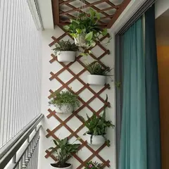 A wooden trellis is a simple and effective way to create a vertical garden on a balcony. It provides a beautiful structure for hanging pots and allows climbing plants to grow, maximizing your green space.