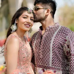 A tender kiss on the forehead. I styled this couple in complementary outfits, with her peach lehenga and his patterned kurta creating a chic and modern look for their sun-drenched haldi ceremony.