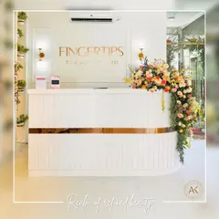 The reception desk at Fingertips Nail Studio sets the tone for the entire space. I designed it with clean white lines, a touch of gold trim, and elegant wall sconces to create a minimalist yet welcoming first impression. The fresh flowers add a soft, natural element to the refined design.