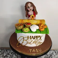 A cake for a South Indian food lover! This design features a spread of delicious, handcrafted fondant treats, including a dosa, idlis, medu vadas, and bowls of sambar and chutney. The custom figurine on top makes it a truly personal and fun birthday surprise.