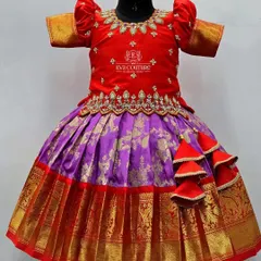 A close-up view of the red and purple Kanchi pattu lehenga on a mannequin. This shows the detail of the scalloped embroidery on the blouse and the richness of the silk skirt.