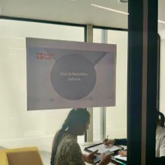 A glimpse into a one on one counseling session in progress at a corporate wellness event. The slide in the background clearly indicates "Diet & Nutrition Advice," showing the focused nature of these consultations.