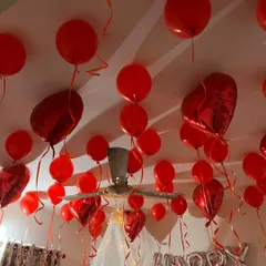 To complete the room surprise, I fill the ceiling with balloons. This setup features red latex and heart-shaped foil balloons with ribbons, creating a fully immersive romantic atmosphere.