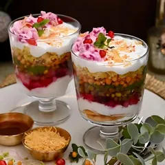 Chaat served in a glass adds a touch of modern elegance to your party. These are layered with chickpeas, potatoes, chutneys, and yogurt, then garnished with pomegranate seeds.