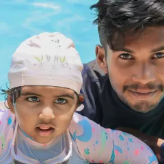 A close-up moment of trust between one of our certified coaches and a young swimmer. We believe early water exposure, guided with care, is the foundation for a lifetime of confidence in the pool.