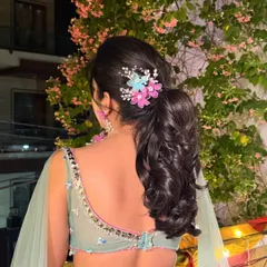 A view of the beautiful hairstyle for Surbhi's Mehendi, adorned with delicate flowers to match her jewelry.