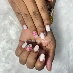 A simple and clean look on natural nails. I used a soft white gel polish as the base and added a pop of color with this hand-painted 3D flower art using carving gel.