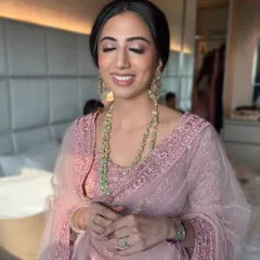 A beautiful, soft smile from a client dressed for a wedding. The pink-toned eyeshadow and glowing skin create a harmonious and ethereal look that enhances her natural beauty.