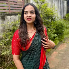 A close-up of this soft and natural makeup look. The focus is on clean skin, gently defined eyes, and a pretty red lip that complements the client's traditional saree.