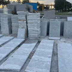 A wide view of my stone yard with various sizes of Bangalore stone slabs and pavers stacked and ready for sale.