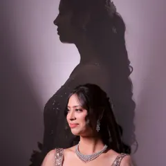 A creative double-exposure style portrait. The bride's silhouette is cast as a shadow behind her, creating a thoughtful and artistic image that is truly unique.