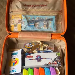 This Rakhi suitcase hamper is themed for a younger child, with a "Bhai you are my Super Hero" card, an Avengers Rakhi, and cute popsicle-shaped highlighters.