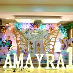 A front-on view of the Butterfly Garden stage, showing the silver sequin backdrop that adds sparkle. The arrangement includes multiple fairy and butterfly characters to create a full fantasy scene.