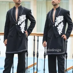 A modern, edgy take on the waistcoat. This black open-front piece is layered over a longline kurta and features white floral appliqué and contrast stitching.