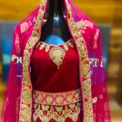A closer look at the intricate gold zardozi and threadwork on the red velvet bridal lehenga. The craftsmanship is designed to look stunning in wedding photos.