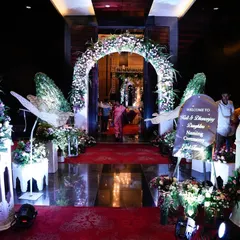 The entrance to the butterfly-themed naming ceremony, featuring a floral arch, white Moroccan-style lanterns, and large, elegant butterfly wings.