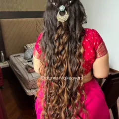 For this naming ceremony look, we created these beautiful, long, flowing curls. The style is enhanced with a simple braid and delicate pearl accessories for a touch of elegance.