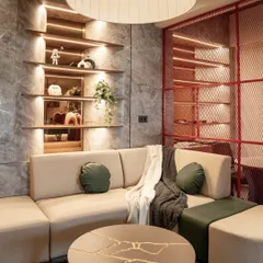 This cozy lounge area within the office provides a space for informal meetings or relaxation. The design features a comfortable sectional sofa, a unique kintsugi-inspired coffee table, and warm, integrated shelving lights.