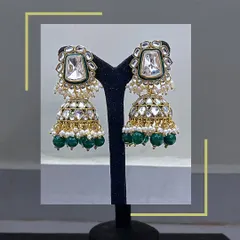 A pair of matching Kundan jhumkas with green beads. Renting a full set of jewellery is a smart way to complete your look without overspending.