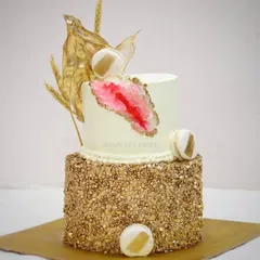 This two-tier geode cake, covered in edible gold sequins, is one of the stunning creations from my advanced cream cake workshop. Students learn how to create the crystal effect and achieve a polished, professional finish.