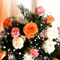 A beautiful bouquet of fresh roses in shades of orange, pink, and white. I use high-quality flowers to create arrangements that add color and elegance to any event space.