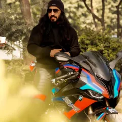 A more relaxed portrait, with the rider leaning against his bike. The natural, wooded background provides a great contrast to the modern machine.