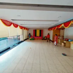 A wide view of the hall during the Janamashtmi setup. You can see the main pooja area being prepared and the simple red and yellow fabric valances I use to decorate the ceiling perimeter.