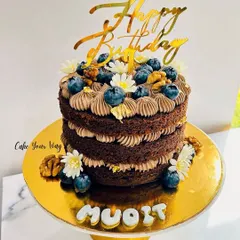 This naked chocolate cake is one of my recent favorites. The rustic, unfrosted sides show off the rich chocolate sponge, layered with creamy frosting and topped with fresh blueberries, walnuts, and delicate white flowers.