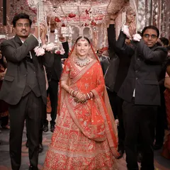 The bride's grand entrance under a traditional phoolon ki chaadar, held by her brothers. This is a classic wedding moment, filled with emotion and anticipation.