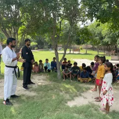 We believe in starting young. Here, we are teaching the basics of martial arts to a group of children in an outdoor society class, focusing on discipline, coordination, and fun.