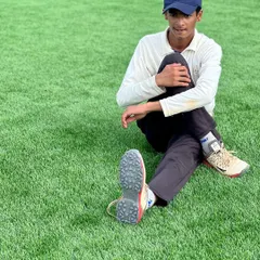 A young cricketer sits for a stretch on the turf. Our fitness sessions are designed to be age-appropriate, building a strong athletic foundation for a long career in the sport.