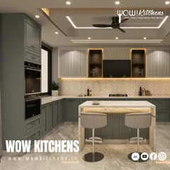 Another angle of this luxurious sage green kitchen, highlighting the built-in ovens and the seamless integration of the cabinetry with the architecture of the room.