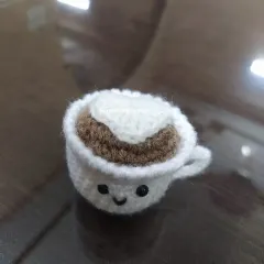 For the coffee lover, this tiny amigurumi coffee cup keychain is a must-have. It features a smiley face and a little heart made of 'foam' on top.