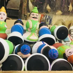 A collection of traditional village-themed dolls in various stages of completion. These figures, representing rural life, are a classic example of Channapatna's storytelling through craft, often collected for display during festivals.