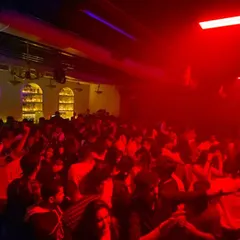 The dancefloor under the red lights, completely full. I read the room and play the tracks that keep everyone on their feet.