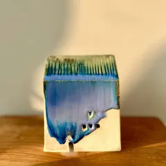 This mini house features a vibrant blue glaze dripping over the unglazed clay body, creating a beautiful contrast.