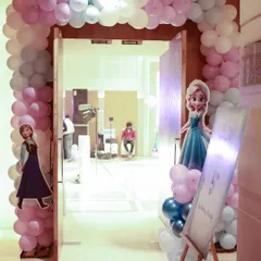 The entrance to the winter wonderland, with a balloon arch and cutouts of Elsa and Anna to welcome the little guests.