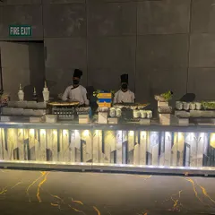 A wide view of our live station spread at a corporate event. This setup includes multiple chefs preparing different dishes simultaneously, offering guests variety and a dynamic culinary show.
