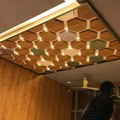 A detailed look at the hexagonal coffered ceiling in the skincare clinic. This intricate design element adds visual interest and conceals lighting, contributing to the space's modern and sophisticated feel.