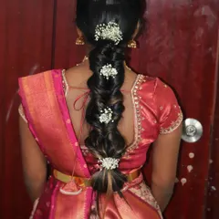 A beautiful messy braid hairstyle, perfect for a pre-wedding event or a reception. This style is adorned with delicate baby's breath flowers, adding a touch of romance.