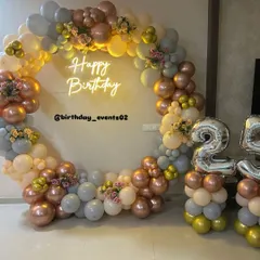 This 25th birthday setup combines our popular balloon ring with silver foil number balloons. The pastel and rose gold color scheme is accented with small floral bouquets for a sophisticated finish.