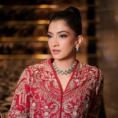 A close-up of the sophisticated makeup look. The skin is flawless and matte, and the eyes are subtly defined to create a chic and polished aesthetic.