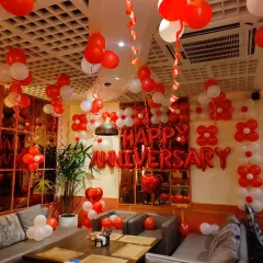 A full room anniversary decoration in a restaurant. I used red and white balloons to fill the space, with "Happy Anniversary" foil letters on a wall of balloon flowers, creating a festive and romantic atmosphere.