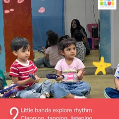 Little hands explore rhythm through clapping, tapping, and listening. Here, children are using simple percussion instruments to feel the beat, an activity that builds both musicality and fine motor skills.